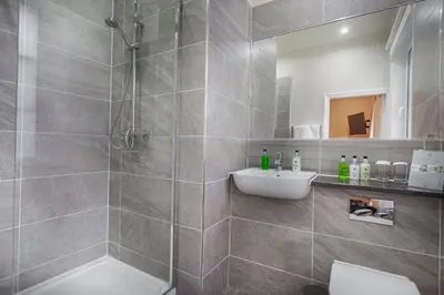 a bathroom with a shower and a toilet and a sink at The Wynnstay Hotel, Oswestry, Shropshire - The Coaching Inn Group in Oswestry