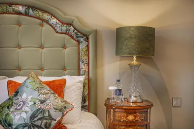 a bedroom with a bed and a lamp on a table at The Wynnstay Hotel, Oswestry, Shropshire - The Coaching Inn Group in Oswestry