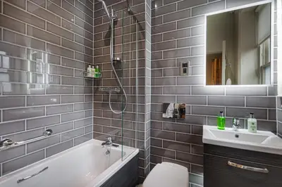 a bathroom with a shower and a tub and a sink at The Wynnstay Hotel, Oswestry, Shropshire - The Coaching Inn Group in Oswestry