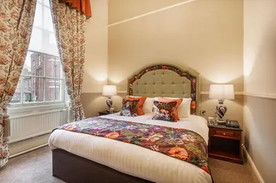 a bedroom with a large bed and a window at The Wynnstay Hotel, Oswestry, Shropshire - The Coaching Inn Group in Oswestry
