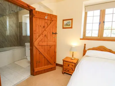 a bedroom with a bed and a sliding barn door at Swn y Nant in Tywyn