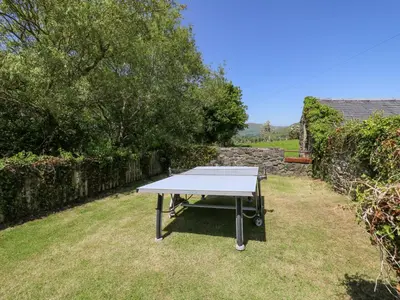 a ping pong table in the grass in a yard at Swn y Nant in Tywyn