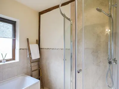 a bathroom with a shower with a tub and a sink at Y Dderwen in Pen-y-bont-fawr