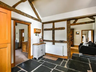 a living room with wooden beams at Y Dderwen in Pen-y-bont-fawr