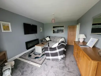a living room with a couch and a tv at Snowdon view, steam railway & Portmeirion nearby in Mynfford