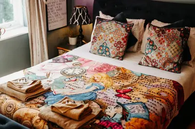 a bed with a blanket with a woman on it at Boutique Shrewsbury Rooms in Shrewsbury