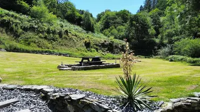a park with a picnic table in the grass at Bear Cottage, Tyn Y Cwm in Scyborycoed