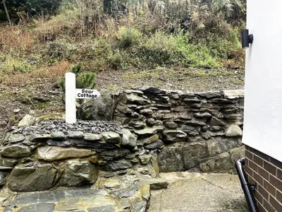 a sign that says fire climbers on a rock wall at Bear Cottage, Tyn Y Cwm in Scyborycoed