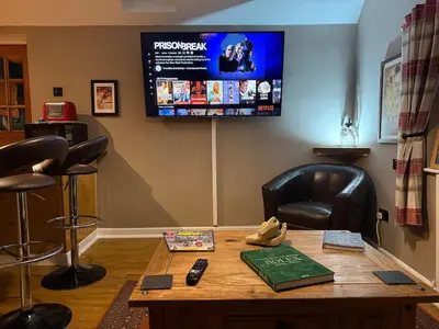 a room with a table with a television on the wall at Bear Cottage, Tyn Y Cwm in Scyborycoed