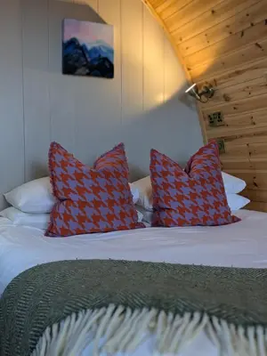 a bedroom with a bed with red pillows on it at Odli Glamping - Deri in Welshpool