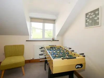 a room with a foosball table and a chair at Mossy Lodge in Shrewsbury