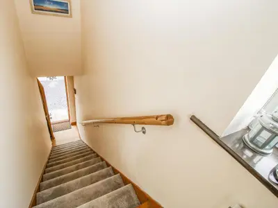 a staircase with a wooden rail and a stair case at Mossy Lodge in Shrewsbury