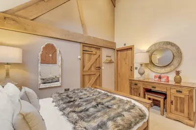 a bedroom with a bed and a mirror on the wall at Hilltop View with Hot Tub in Brecon