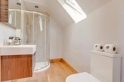a bathroom with a shower and a sink and a toilet at Hilltop View with Hot Tub in Brecon