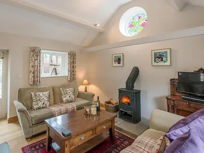 a living room with a couch and a stove at Walkmill Lodge in Wentnor