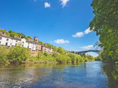 a river in a town with a bridge in the background at Mashers Barn in Bucknell