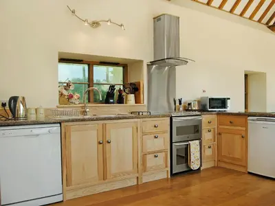 a kitchen with wooden cabinets and a stove top oven at Mashers Barn in Bucknell