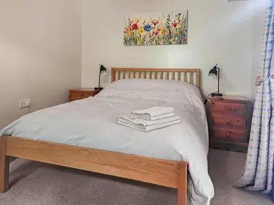 a bedroom with a bed with towels on it at Garden Lodge in Llanvair Waterdine