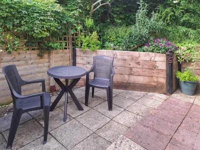 two chairs and a table and a table and two chairs at Garden Lodge in Llanvair Waterdine
