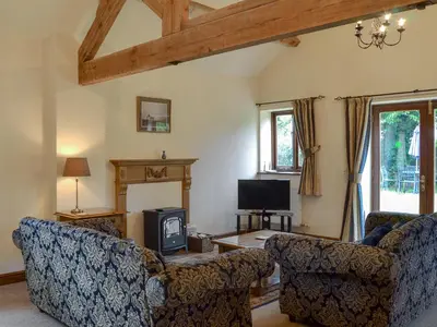 a living room with two couches and a tv at Skimblescott Barn in Monkhopton