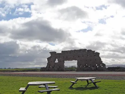 two picnic tables in front of a stone building at Skimblescott Barn in Monkhopton