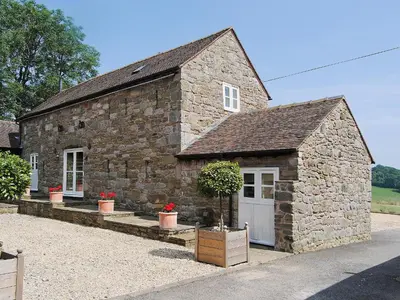 a small stone building with a white door at St Vincent in Plaish