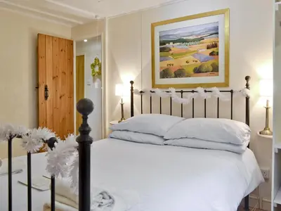 a bedroom with a bed with white pillows at The Summer House in Easthope