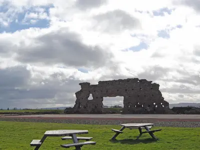 two picnic tables in front of a stone building at Bequia - Reet in Frodesley