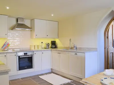 a white kitchen with white cabinets and a sink at Bequia - Reet in Frodesley