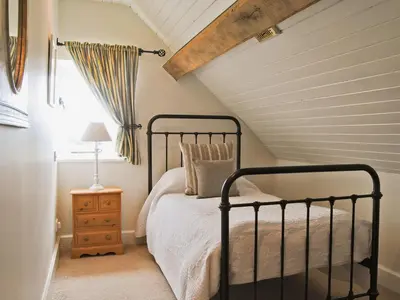 a bedroom with a black bed and a window at Bequia - Reet in Frodesley