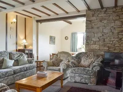 a living room with couches and a stone wall at Grove Sprightly Barn in Craven Arms