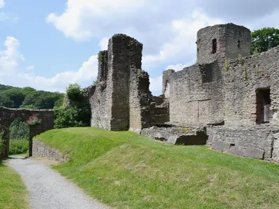 an old castle on a hill with a dirt road at Grove Sprightly Barn in Craven Arms
