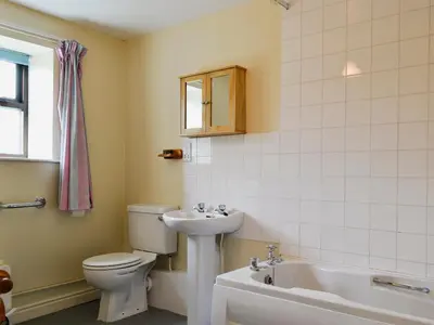 a bathroom with a toilet and a sink and a tub at Halford Big Barn in Halford