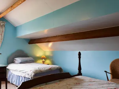 a bedroom with two beds with blue walls at Halford Big Barn in Halford