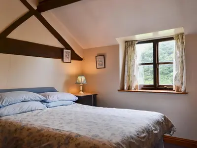 a bedroom with a large bed and a window at Halford Big Barn in Halford