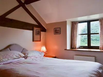 a bedroom with a large white bed with a window at Halford Big Barn in Halford
