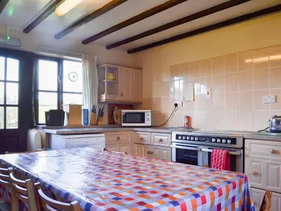 a kitchen with a table with a checkered table cloth at Dinhope Big Barn in Craven Arms