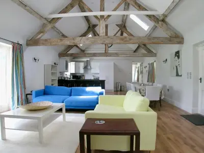 a living room with a blue couch and a table at Cow Shed in Farden