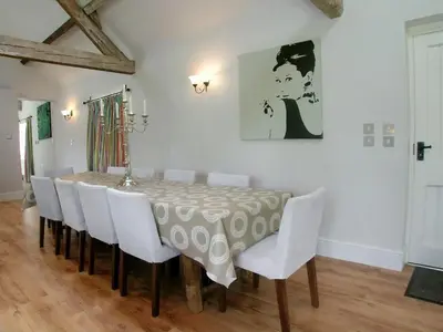 a dining room with a table and white chairs at Cow Shed in Farden