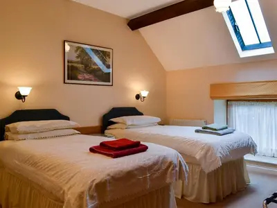 a bedroom with two beds with towels on them at Stoke Court Farm Barn in Stoke Saint Milborough