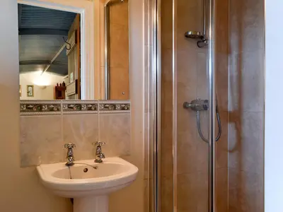 a bathroom with a sink and a shower at Stoke Court Farm Barn in Stoke Saint Milborough