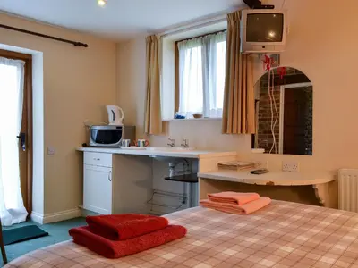 a bedroom with a bed with red towels on it at Stoke Court Farm Barn in Stoke Saint Milborough