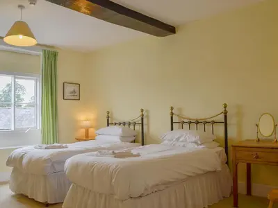two twin beds in a room with a window at Cronkhill Farmhouse in Wroxeter