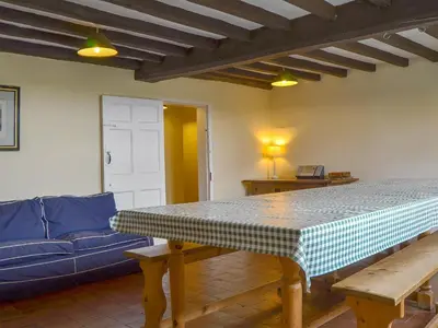 a living room with a table and a blue couch at Cronkhill Farmhouse in Wroxeter
