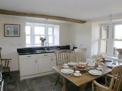 a kitchen with a wooden table with chairs and a dining room at Mouse Castle Barn in Hay-on-Wye