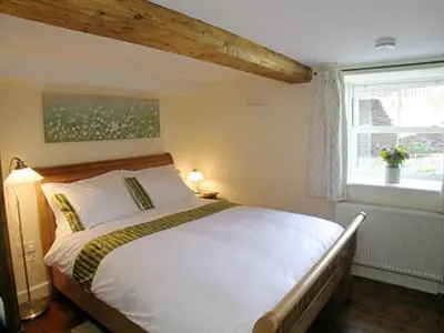 a bedroom with a white bed and a window at Mouse Castle Barn in Hay-on-Wye