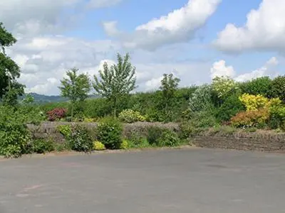 an empty parking lot with trees and bushes at Mouse Castle Barn in Hay-on-Wye