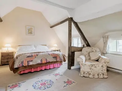 a bedroom with a bed and a chair at Walnut Tree Cottage in Bucknell