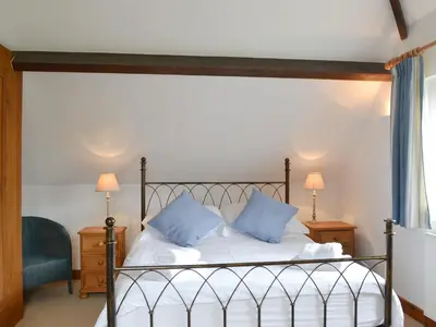 a bedroom with a bed with blue pillows on it at The Stables in Eardisland
