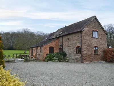 an old brick building with a picnic table in a field at Howards End in Middleton on the Hill